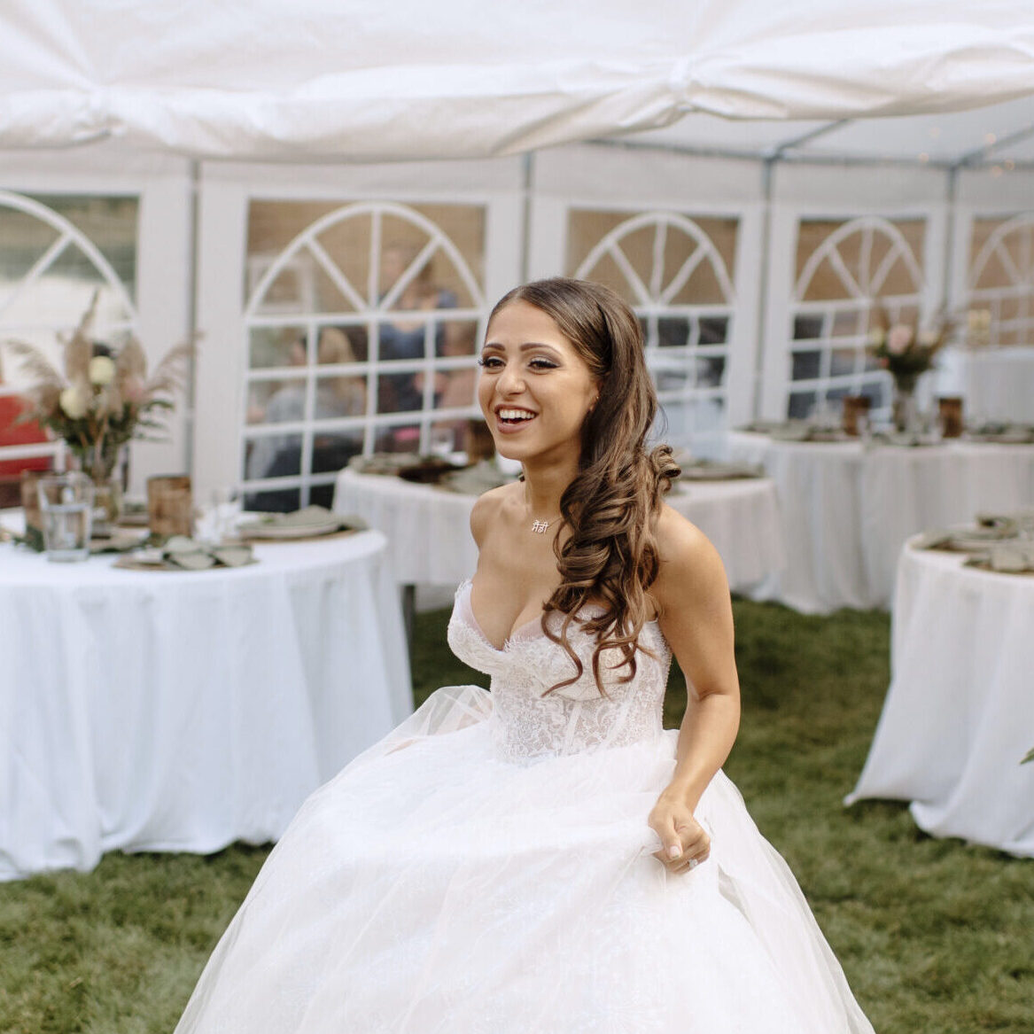 Bride in a beautiful white gown enjoying her outdoor wedding reception.