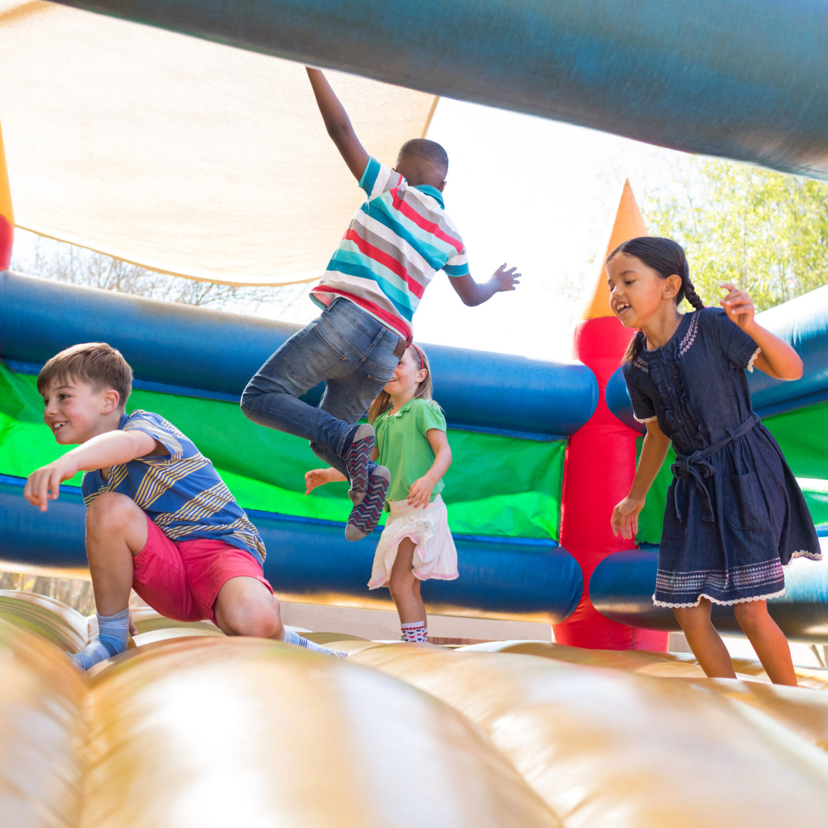 Friends jumping on bouncy castle at playground